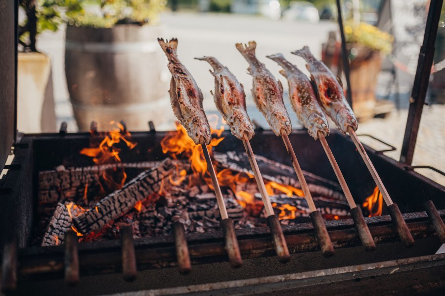 Steckerlfisch, © Niederösterreich Werbung/Daniela Führer Steckerlfisch über offenem Feuer gegrillt, traditionelle Zubereitung.