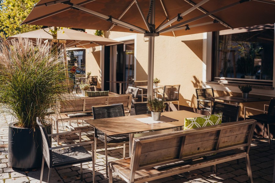 Ein Platz an der Sonne, © Niederösterreich Werbung/Daniela Führer Sonniger Außenbereich eines Cafés mit Tischen, Stühlen und Sonnenschirmen.