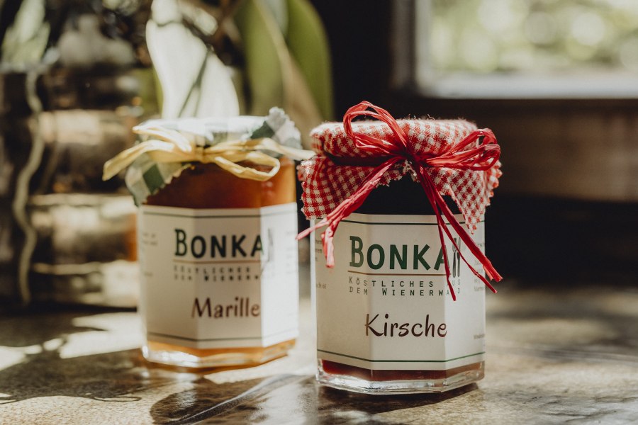 Ab-Hof-Verkauf von Selbstgemachtem, © Niederösterreich Werbung/Sophie Menegaldo Zwei Gläser Marmelade mit Etiketten 'Bonka', eins mit Marille, das andere mit Kirsche, auf einem Tisch.
