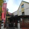 Wirtshaus Grüner Baum, © Wirtshaus Grüner Baum, Foto: Magdalena Endes Eingang des Gasthofs Grüner Baum mit rotem Banner und Willkommensschild.