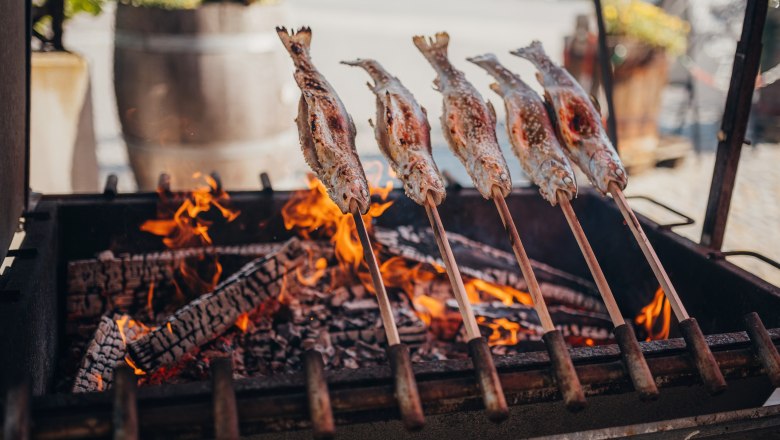 Steckerlfisch, © Niederösterreich Werbung/Daniela Führer Steckerlfisch über offenem Feuer gegrillt, traditionelle Zubereitung.