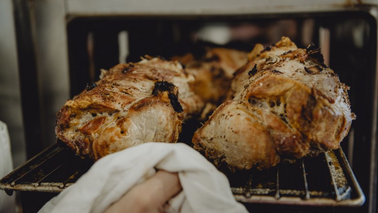 Schweinebratl direkt aus dem Ofen, © Niederösterreich Werbung/Rita Newman Frisch gebratenes Schweinefleisch wird aus dem Ofen genommen.
