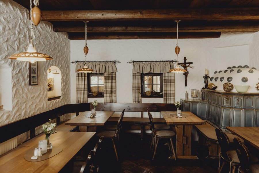 Waldviertler Stube, © Niederösterreich Werbung/Sophie Menegaldo Gemütliche Stube mit Holzmöbeln, Kachelofen und rustikaler Dekoration.