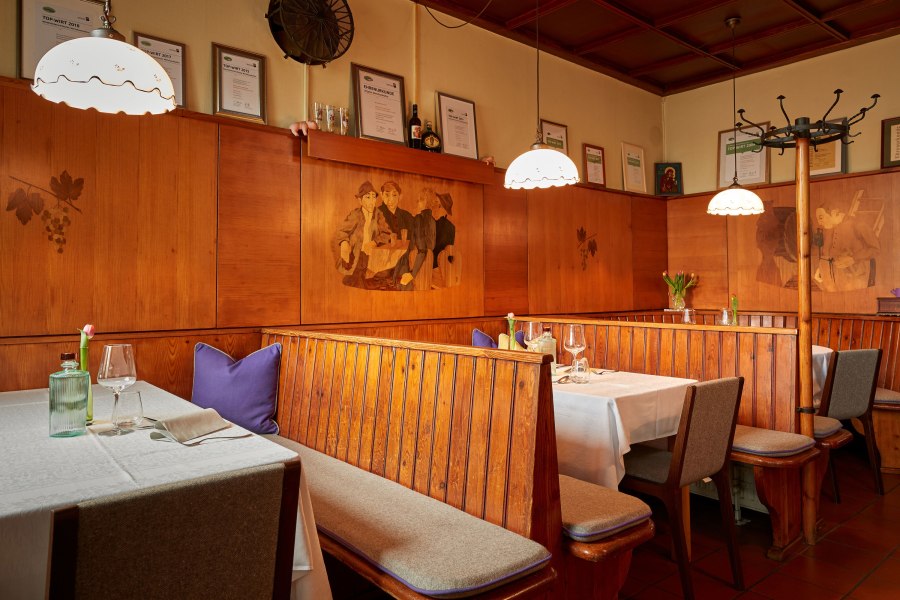 Urige Wirtshausstube, © Niederösterreich Werbung/Andreas Hofer Gemütliches Restaurant mit Holzbänken, Tischdecken und Wanddekorationen.