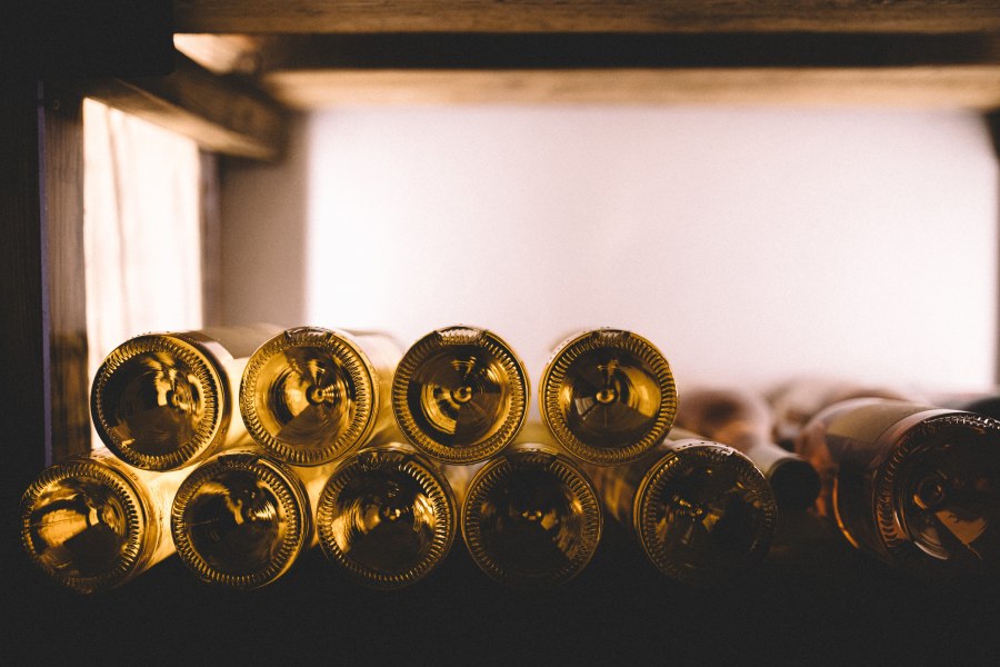 Gut gefüllter Weinkeller, © Niederösterreich Werbung/Mara Hohla Nahaufnahme von Weinflaschen in einem Regal, die horizontal gestapelt sind.