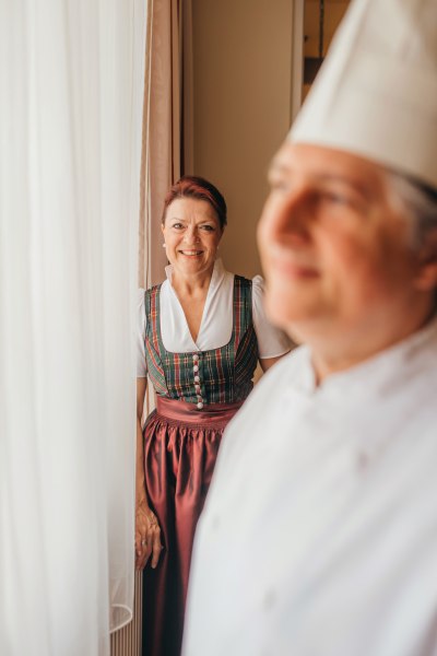 Waldviertler Haubenküche, © Niederösterreich Werbung/Daniela Führer Eine Frau in traditioneller Kleidung steht neben einem Koch in weißer Uniform.