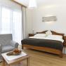 Zimmer Krumbacherhof, © Wiener Alpen / Bene Croy Helles Zimmer mit Doppelbett, Sessel und Tisch mit Obstschale.