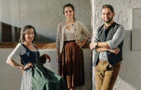 Margit Werner-Pietsch, Johanna und Lukas Werner, © Niederösterreich Werbung/Julius Hirtzberger Drei Personen in traditioneller Kleidung in einem hellen Raum.