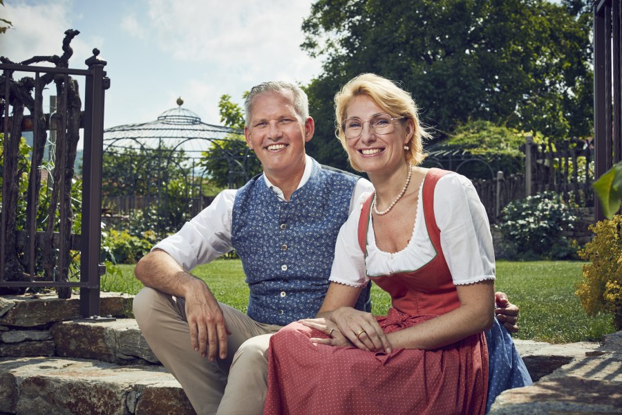 Manuela und Christian Wildeis, © Niederösterreich Werbung/Andreas Hofer Familie Wildeis in Trachtenkleidung sitzen lächelnd im Garten.