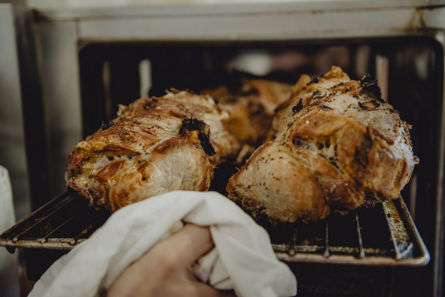 Schweinebratl direkt aus dem Ofen, © Niederösterreich Werbung/Rita Newman Frisch gebratenes Schweinefleisch wird aus dem Ofen genommen.