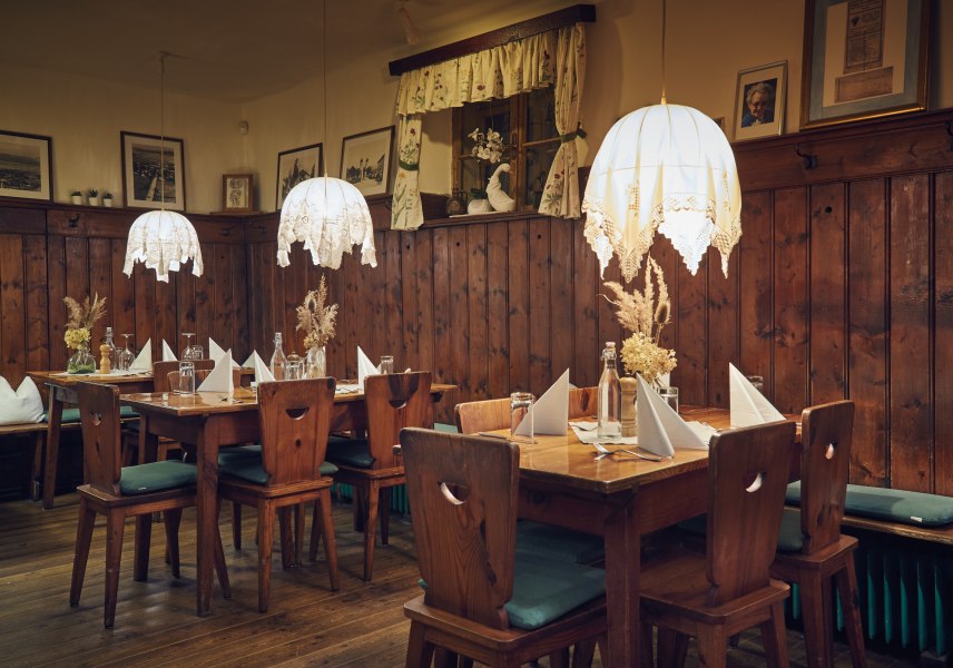 Urige Stube, © Niederösterreich Werbung/Andreas Hofer Gemütliche Stube mit Holzmöbeln, Tischdekoration und hängenden Lampen.