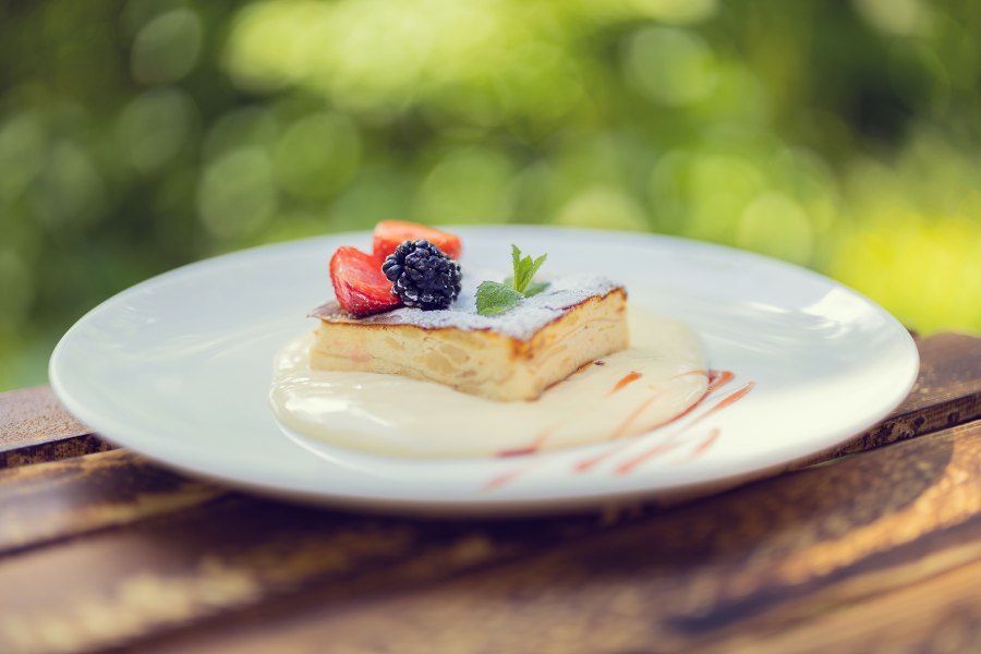 Große Auswahl für den süßen Gaumen, © Schlosstaverne Lunz/Martin Stellnberger Ein Dessert mit Beeren auf einem Teller im Freien.