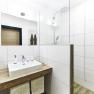 Badezimmer Krumbacherhof, © Wiener Alpen / Bene Croy Modernes Badezimmer mit Waschbecken, Spiegel und Dusche.