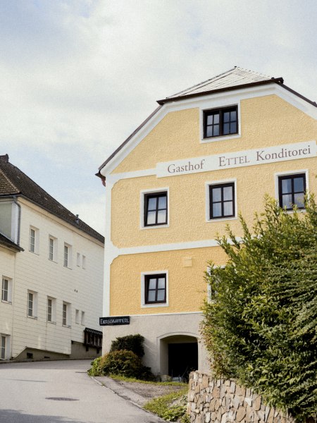 Gasthof in St. Leonhard, © Niederösterreich Werbung/Julius Hirtzberger Gelbes Gebäude mit der Aufschrift 'Gasthof Ettel Konditorei' in St. Leonhard.