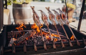 Steckerlfisch, © Niederösterreich Werbung/Daniela Führer Steckerlfisch über offenem Feuer gegrillt, traditionelle Zubereitung.