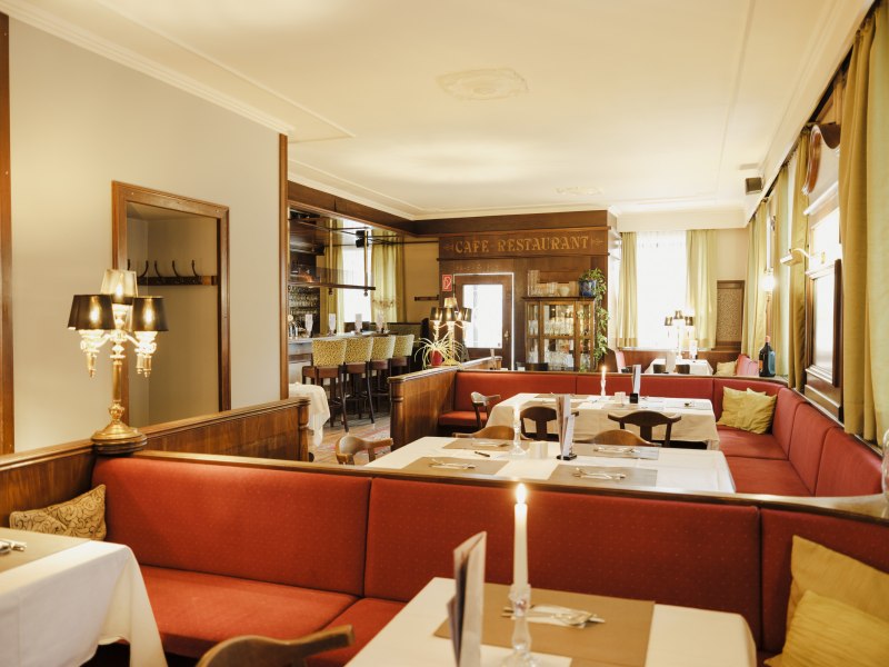 Gemütliche Kaffeehaus-Atmosphäre, © Niederösterreich Werbung/Michael Reidinger Gemütliches Café-Restaurant mit roten Sitzbänken und Kerzenlicht.