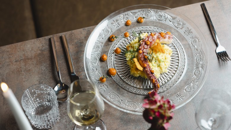Internationale Einflüsse ergänzen heimische Kochlinie, © Niederösterreich Werbung/Michael Reidinger Elegantes Gericht mit Oktopus auf Risotto, dekorativ serviert.