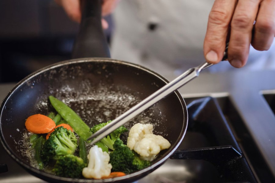 Haubenküche an der Moststraße, © Niederösterreich Werbung/Daniela Führer Koch rührt Gemüse in einer Pfanne um.