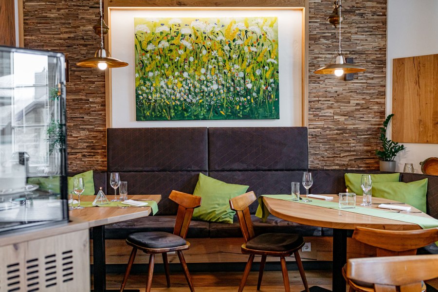 Gastzimmer mit liebevoll ausgewählten Details, © Niederösterreich Werbung/Mara Hohla Gemütliches Gastzimmer mit Holzmöbeln, grünen Kissen und einem Blumenbild an der Wand.