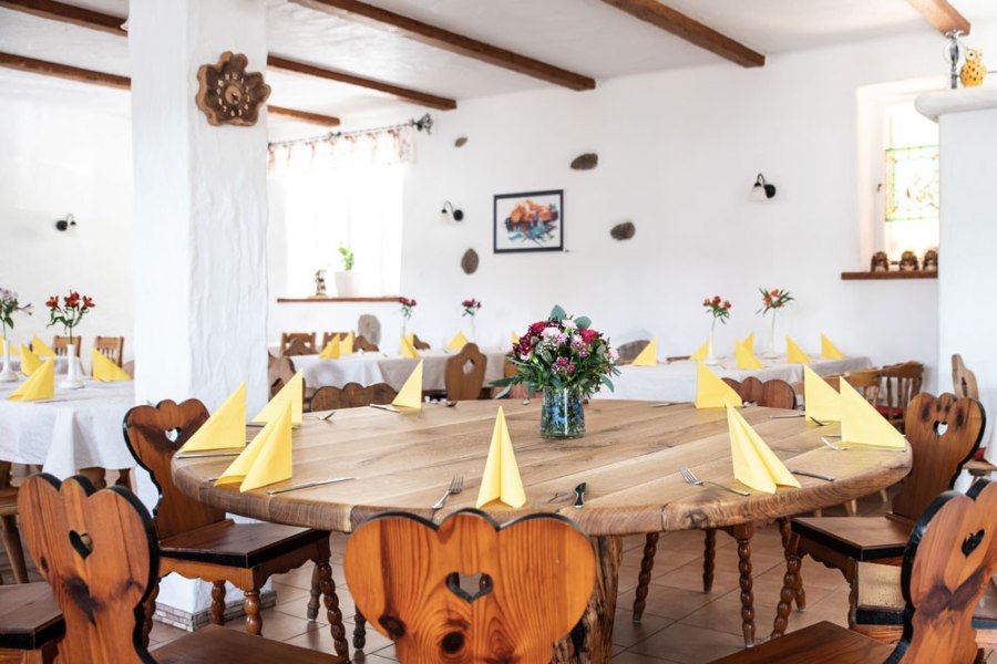 Stube mit Musikstammtisch, © Niederösterreich Werbung/Nadja Büchler Ein gemütlicher Raum mit Holztischen und -stühlen, gelben Servietten und Blumenarrangements.