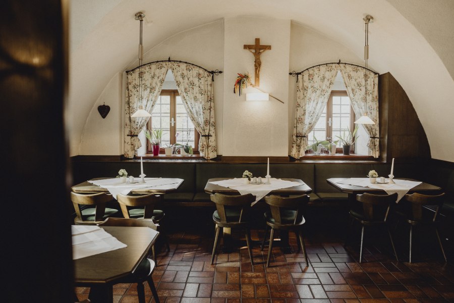 Traditionelle Stube, außergewöhnlich gute Küche, © Niederösterreich Werbung/Sophie Menegaldo Gemütliches Gasthaus mit Holzmöbeln und dekorativen Vorhängen.