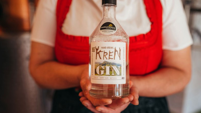 International prämierte Edelbrände, © Niederösterreich Werbung/Daniela Führer Person hält eine Flasche Krenn Gin mit Auszeichnungsetikett.