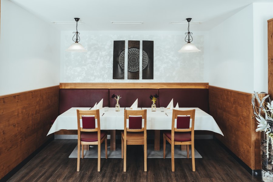 Innovation trifft Tradition in Groß Gerungs, © Niederösterreich Werbung/David Schreiber Ein stilvoll gedeckter Tisch in einem Restaurant mit Holzverkleidung und moderner Kunst an der Wand.