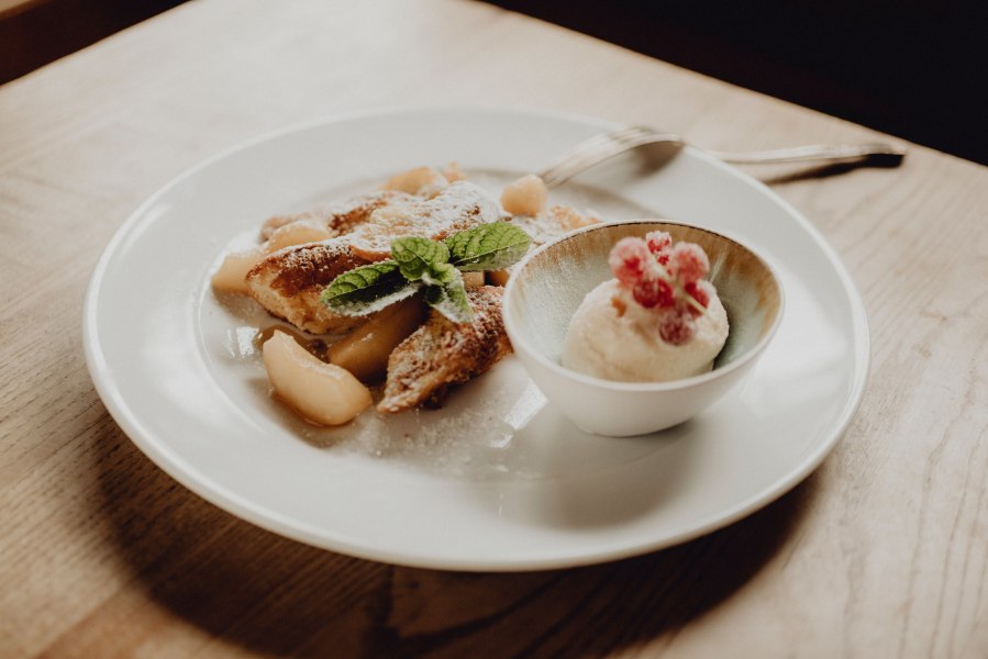 Der Name ist Programm: Apfelschmarren mit Topfen-Rum-Eis, © Niederösterreich Werbung/Rita Newman Ein Teller mit Apfelschmarren und einer Schale Topfen-Rum-Eis, garniert mit Minzblättern und roten Beeren.