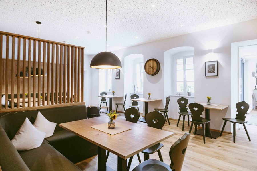 Gemütliche Atmosphäre in der lichtdurchfluteten Gaststube, © Astrid Bartl Moderne Gaststube mit Holzmöbeln und stilvoller Beleuchtung.