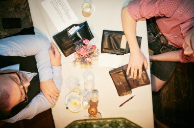 Kassasturz: Service-Brieftasche liegt auf Wirtshaustisch, 2 Restaurantfachmänner sitzen am Tisch