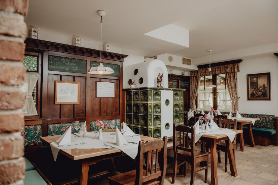 Heimeliges Traditionshaus am Fuße des Schneebergs, © Niederösterreich Werbung/Rita Newman Gemütliches Restaurant mit Holzmöbeln, Kachelofen und dekorierten Tischen.