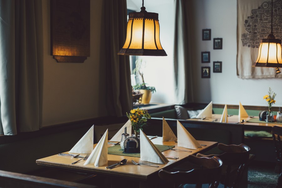 Traditionelle Stube, © Niederösterreich Werbung/David Schreiber Gemütliche, traditionell eingerichtete Stube mit gedeckten Tischen und warmem Licht.