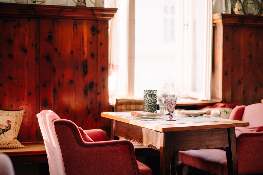 Traditionshaus aus dem 16. Jahrhundert, © Niederösterreich Werbung/Julius Hirtzberger Gemütliche Einrichtung mit Holzwänden und roten Sesseln.