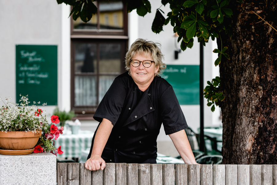 Gasthof Ebner, © Niederösterreich Werbung/David Schreiber Inmitten der malerischen Landschaft des Mostviertels strahlt die Wirtin Martina Ebner eine herzliche Gastfreundschaft aus. Umgeben von blühenden Pflanzen und der einladenden Atmosphäre des Gasthofs, lädt sie die Gäste ein, die kulinarischen Köstlichkeiten der Region zu genießen. Hier wird Tradition gelebt und jeder Besuch zu einem unvergesslichen Erlebnis.