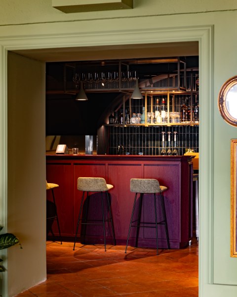 Stilvolles Ambiente, © thefirstthought Elegante Bar mit roten Holzmöbeln und hohen Stühlen.