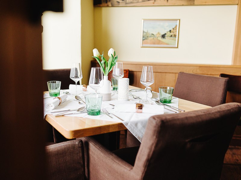 Einladendes Gasthaus mit regionaler Waldviertler Küche, © Niederösterreich Werbung/Mara Hohla Ein elegant gedeckter Tisch in einem Gasthaus mit Gläsern, Besteck und weißen Tulpen in einer Vase.