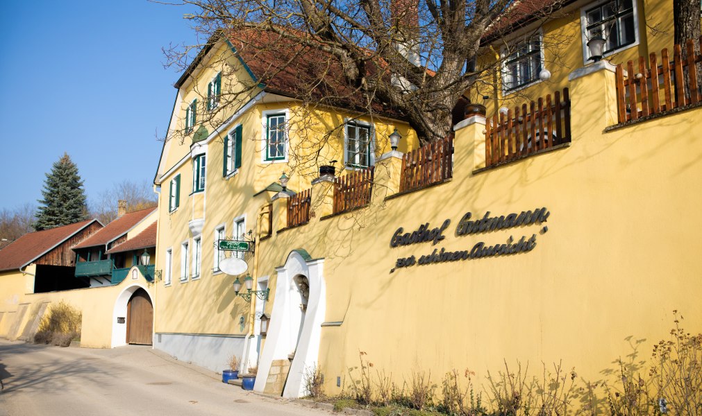 Gasthaus im Kamptal, © Niederösterreich Werbung/Mara Hohla Gelbes Gasthaus mit grünen Fensterläden und Holzzaun, sonniger Tag.