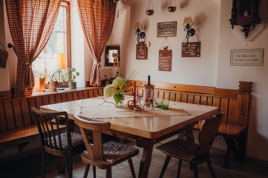 400 Jahre alte Holztramdecke im Gastzimmer, © Niederösterreich Werbung/Daniela Führer Gemütliches Gastzimmer mit Holztisch, Stühlen und dekorativen Elementen an den Wänden.