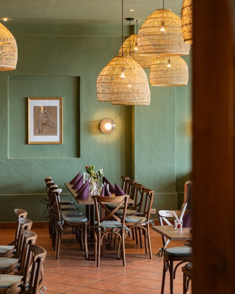 Tradition trifft Charme, © thefirstthought Gemütlicher Essbereich mit Holztisch, Stühlen und geflochtenen Lampen.