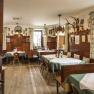 Die Gaststube im Wirtshaus Grüner Baum, © Kurt Pinter Gemütliche Gaststube mit Holzmöbeln, grünen Vorhängen und Jagdtrophäen an der Wand.