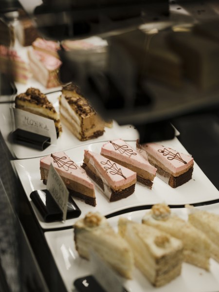 Torten aus hauseigener Konditorei, © Niederösterreich Werbung/Michael Reidinger Vitrine mit verschiedenen Kuchenstücken auf weißen Tellern.
