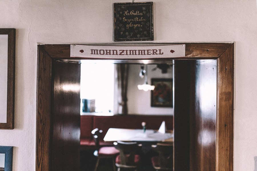 Mohnzimmer, -shop und Mohnmühlen-Sammlung, © Niederösterreich Werbung/Mara Hohla Ein einladender Durchgang zu einem gemütlichen Wirtshaus, wo die Tradition der Wirtshauskultur lebendig wird. Die rustikale Holzverkleidung und die warmen Farben schaffen eine behagliche Atmosphäre, die zum Verweilen einlädt. Hier können Besucher die köstlichen Spezialitäten der Region genießen und die herzliche Gastfreundschaft erleben.