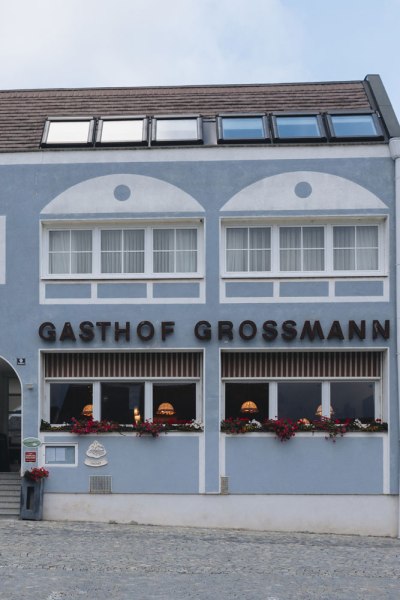 Ein Gasthof für Ausflüger und Stammgäste, © Niederösterreich Werbung/David Schreiber Fassade des Gasthofs Grossmann mit blauer Wand und Blumenkästen.