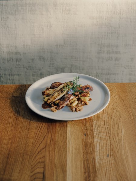 Saltimbocca vom Hirsch mit Gnocchi, © Niederösterreich Werbung/Julius Hirtzberger Ein Teller mit Saltimbocca vom Hirsch und Gnocchi auf einem Holztisch.