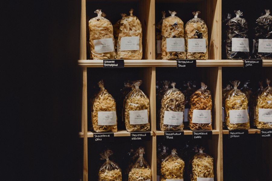 Hauseigene Nudelmanufaktur, © Niederösterreich Werbung/Sophie Menegaldo Regal mit verschiedenen Sorten verpackter Pasta in Tüten.