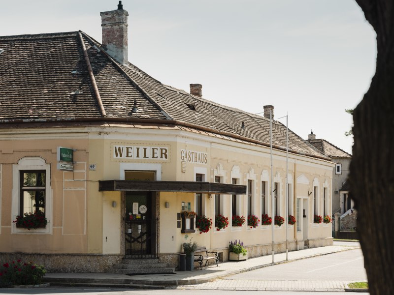 Ein Haus mit Geschichten in Laa a. d. Thaya, © Niederösterreich Werbung/Michael Reidinger Historisches Gasthaus Weiler in Laa an der Thaya mit blumengeschmückten Fenstern.