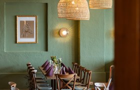 Tradition trifft Charme, © thefirstthought Gemütlicher Essbereich mit Holztisch, Stühlen und geflochtenen Lampen.