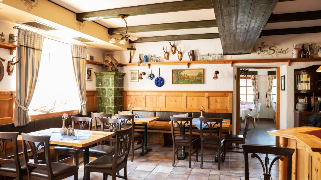 Gemütliche Stube mit Ab Hof Verkauf, © Niederösterreich Werbung/Nadja Büchler Gemütliche Stube mit Holzmöbeln, Kachelofen und Jagdtrophäen an den Wänden.