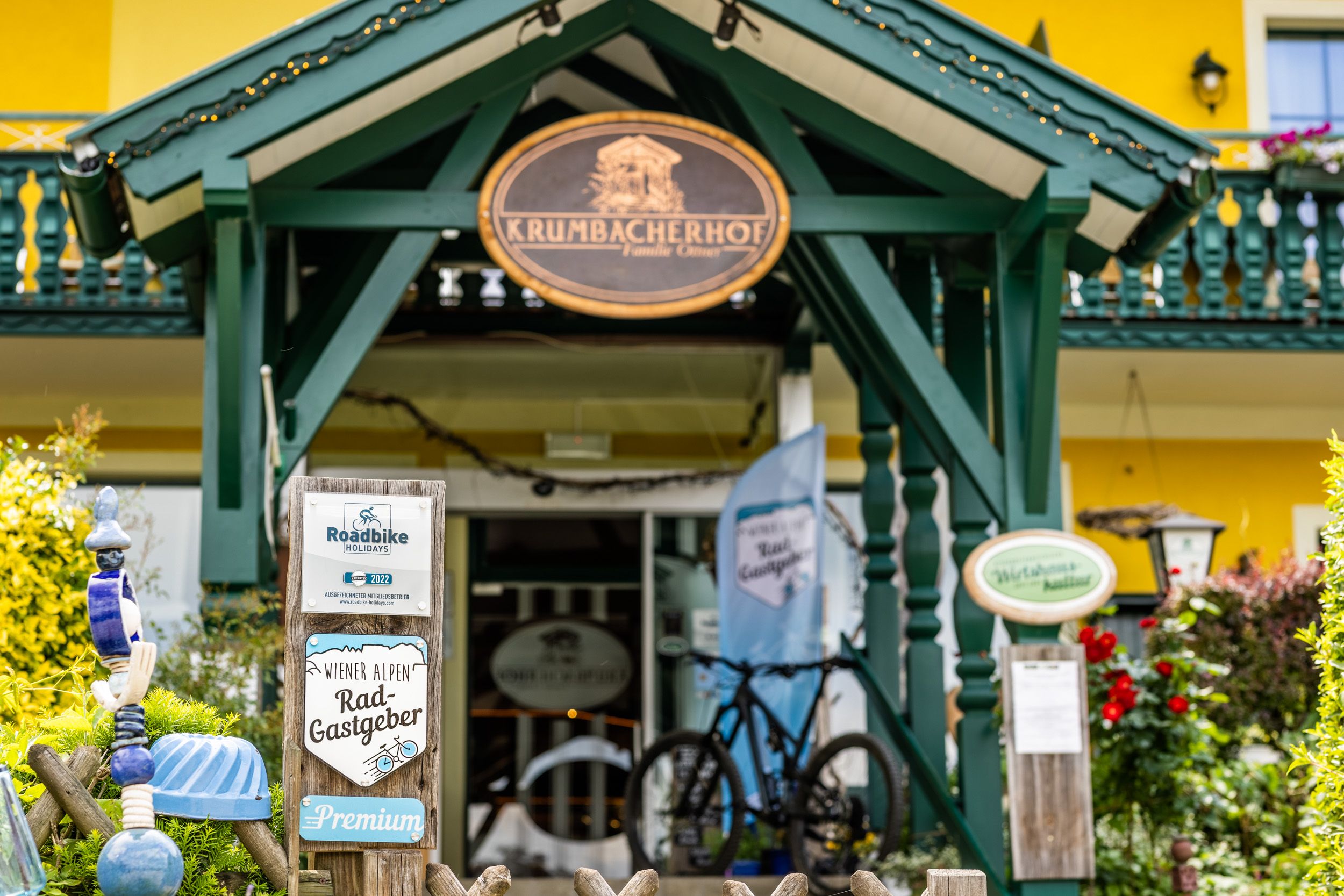 Eingang des Krumbacherhofs mit Fahrrad und Schildern für Radfahrer.