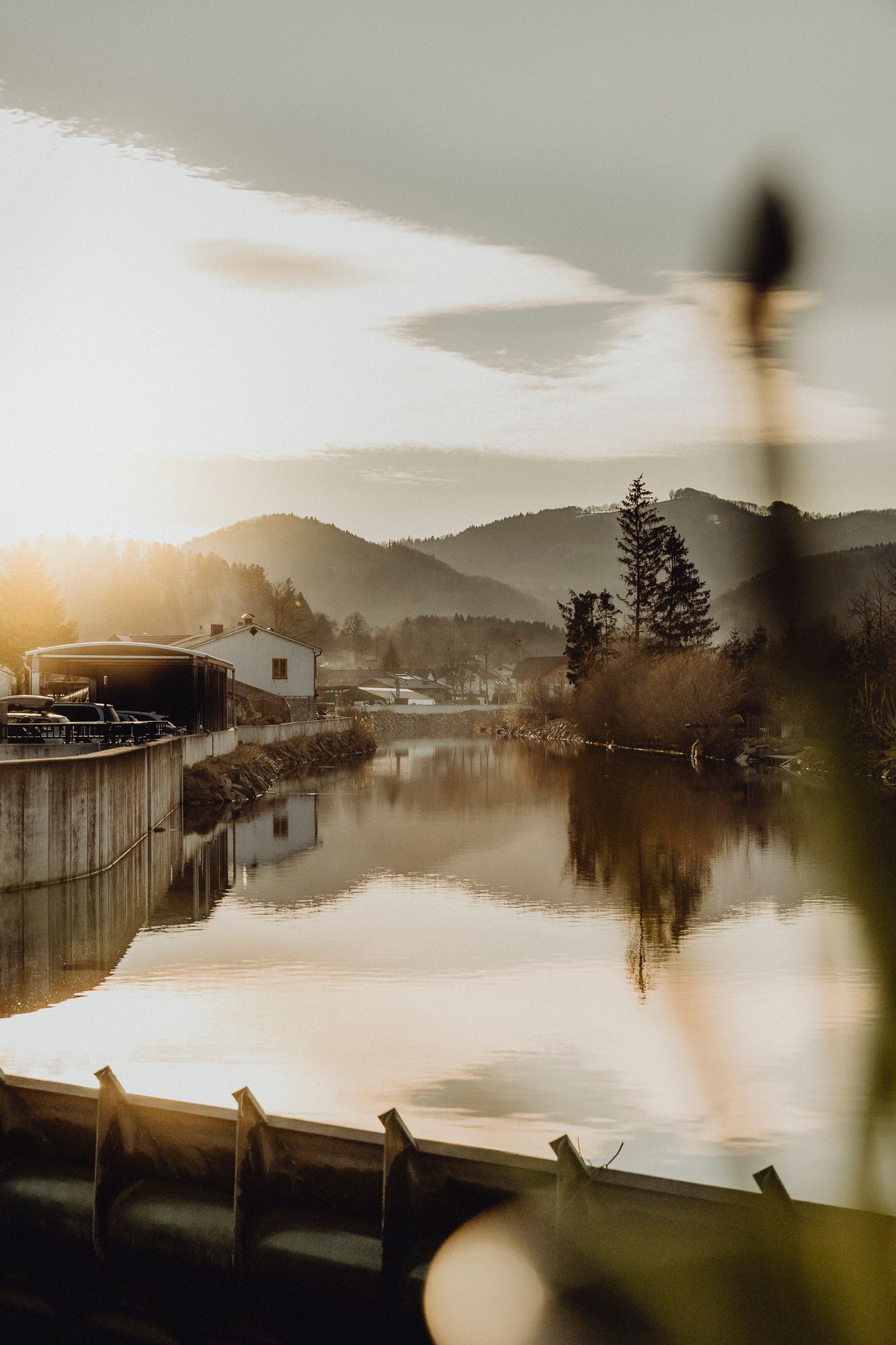 Fluss mit Spiegelung der Landschaft im Sonnenuntergang.